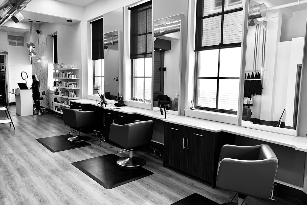 Friseursalon mit Frisierplätzen und Produktregal in Schwarz-Weiß