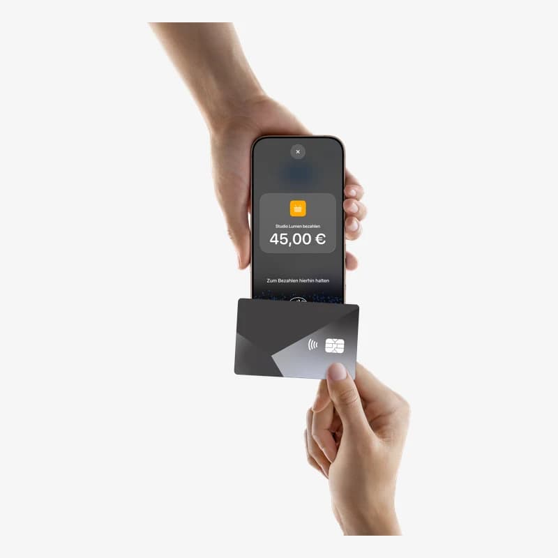 Tap to Pay auf dem iPhone: Eine Karte wird an ein iPhone gehalten, auf dem „Studio Lumen bezahlen, 45,00 €“ steht