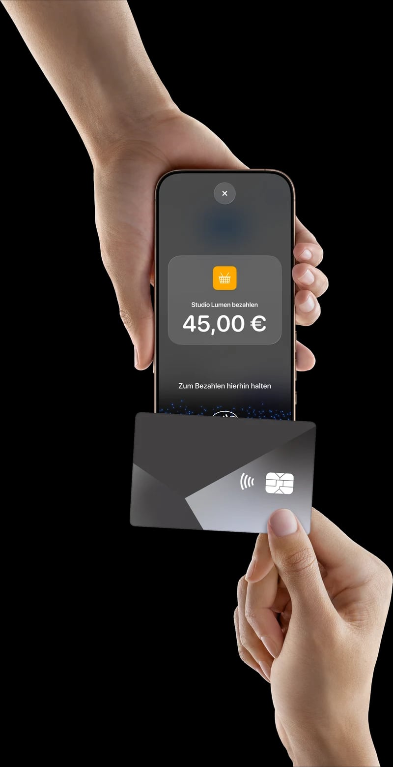 Tap to Pay auf dem iPhone: Eine Hand hält ein iPhone mit „Studio Lumen bezahlen, 45,00 €“ und „Zum Bezahlen hierhin halten“, eine zweite Hand hält eine Karte daran